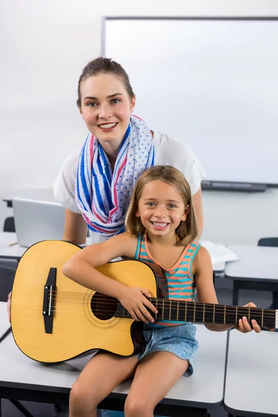 Profesor ayudando a chica a tocar la guitarra —  Fotos de Stock