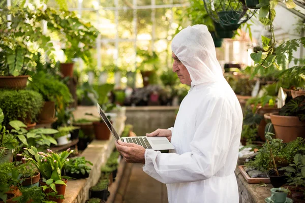 Scienziato maschio in tuta pulita utilizzando il computer portatile — Foto Stock