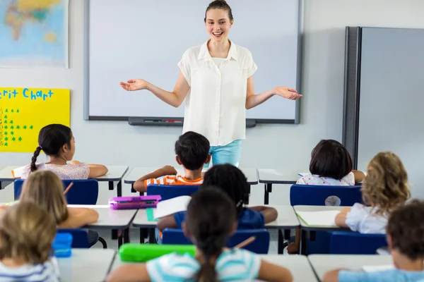 Lärare med armarna utsträckta i klassrummet — Stockfoto