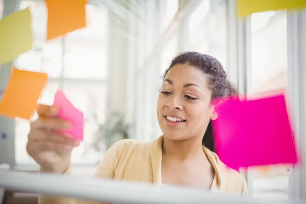 Businesswoman sticking adhesive notes — Stock Photo, Image