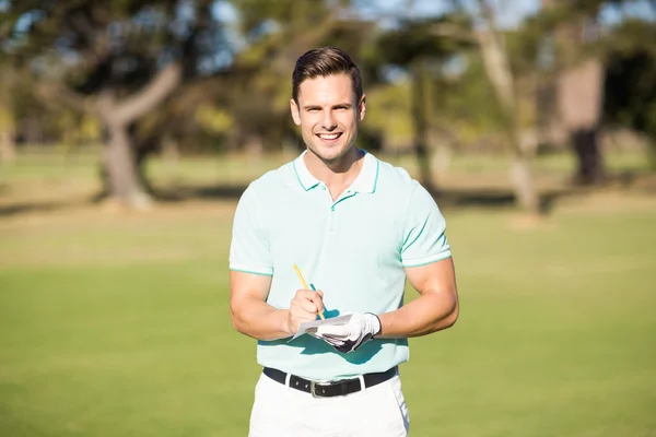 Golfista sorridente con carta punteggio — Foto Stock