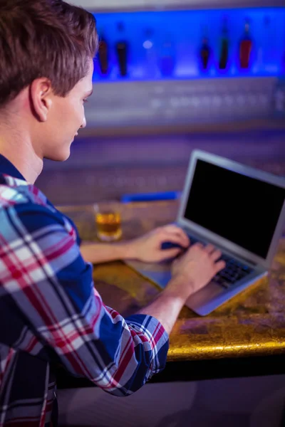 Hombre usando el ordenador portátil en barra de bar —  Fotos de Stock