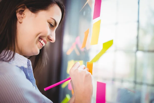 Creative businesswoman writing on sticky notes — Stock Photo, Image