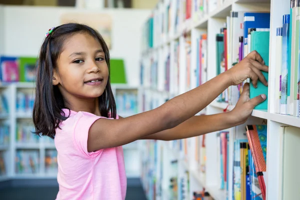 Meisje zoeken van boeken in de schoolbibliotheek — Stockfoto