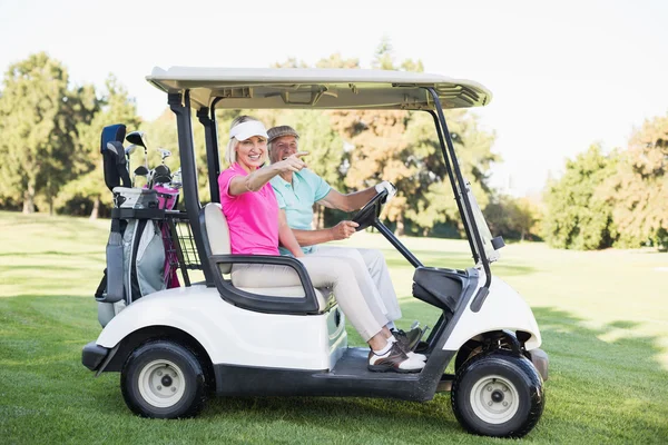Mature woman pointing in golf buggy — Stock Photo, Image