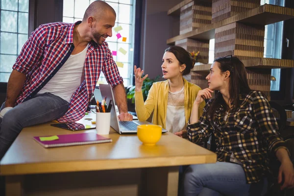 Empresarios creativos discutiendo en el escritorio — Foto de Stock