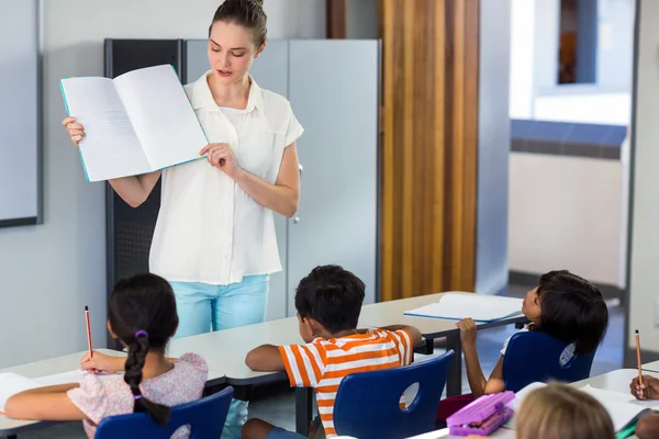 Leraar weergegeven: boek aan schoolkinderen — Stockfoto