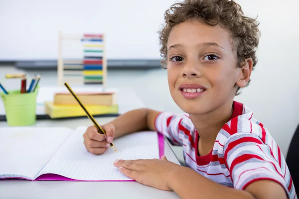 Lächelnder Junge lernt am Schreibtisch — Stockfoto