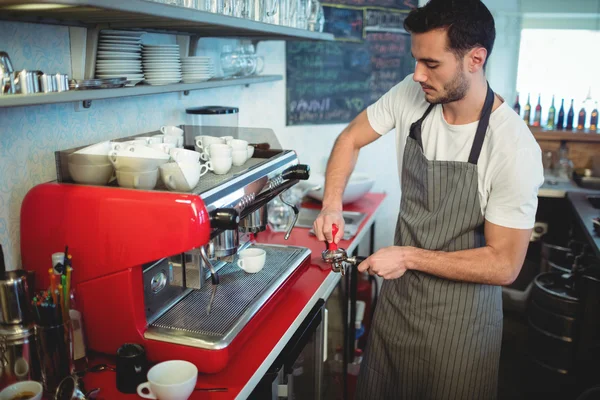 Knappe werknemer met behulp van de zeef op café — Stockfoto