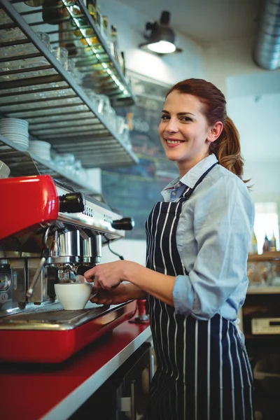 Servitrisen hälla kaffe från espresso maker — Stockfoto