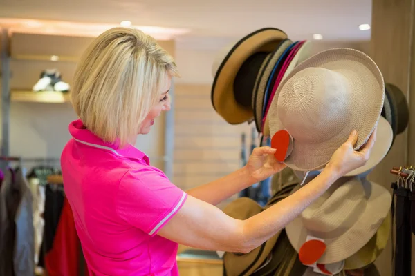 Rijpe vrouw op zoek naar een hoed — Stockfoto