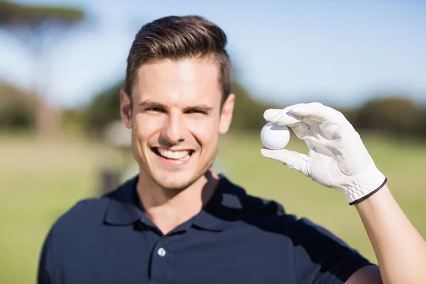 Mladý muž zobrazeno golfový míček — Stock fotografie