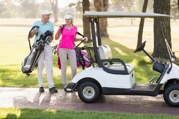 Mature golfer couple by golf buggy — Stock Photo, Image