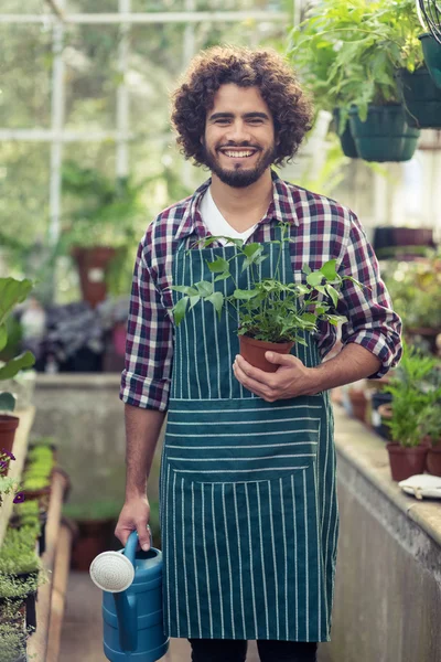 Jardinero sosteniendo maceta planta y regadera — Foto de Stock