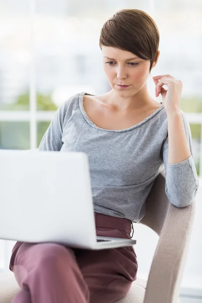 Ung kvinna som använder bärbar dator — Stockfoto