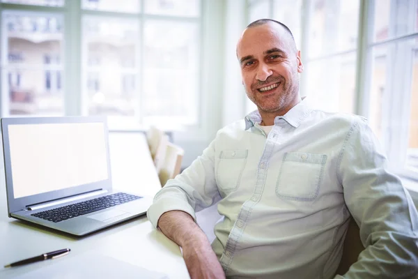 Lachende zakenman zitten door laptop — Stockfoto