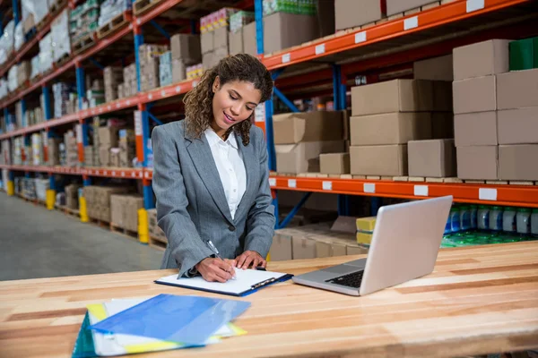 Mujer de negocios escribiendo en portapapeles — Foto de Stock