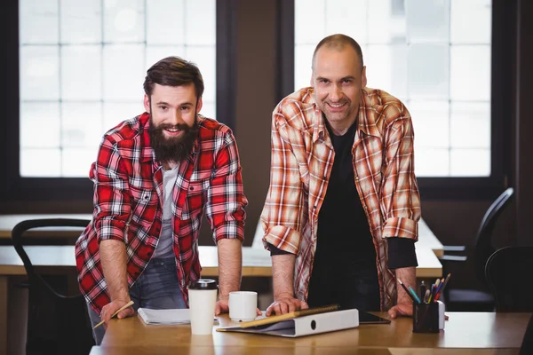 Creative coworkers leaning at desk — Stock Photo, Image
