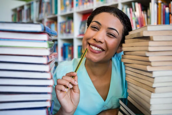 Nachdenkliche junge Frau in Bibliothek — Stockfoto