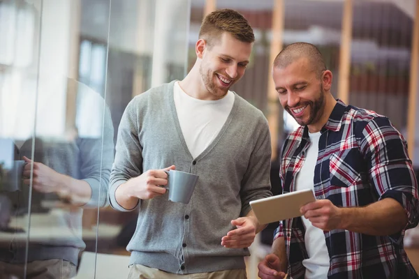 Businessman with colleague using tablet in office — Stock Photo, Image