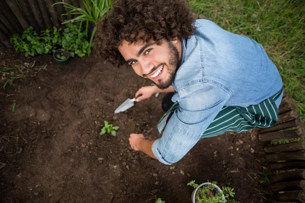 Jardinero sonriente plantando fuera del invernadero — Foto de Stock