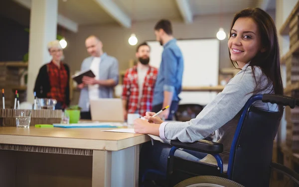 Confident disabled businesswoman writing — Stock Photo, Image