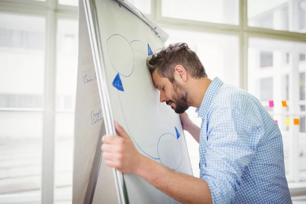 Empresário cansado segurando quadro branco no escritório — Fotografia de Stock