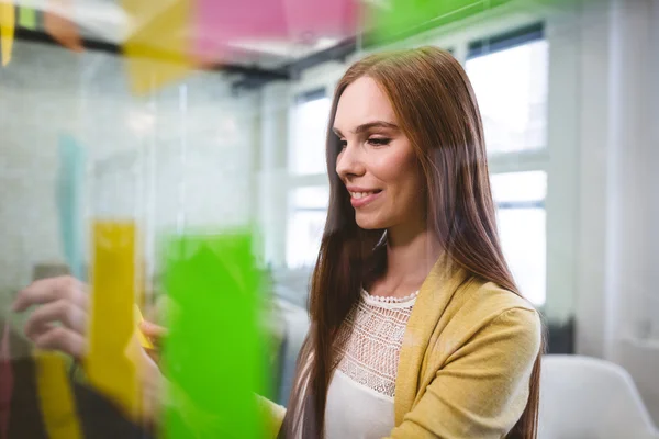 Business woman attaching sticky notes — стоковое фото