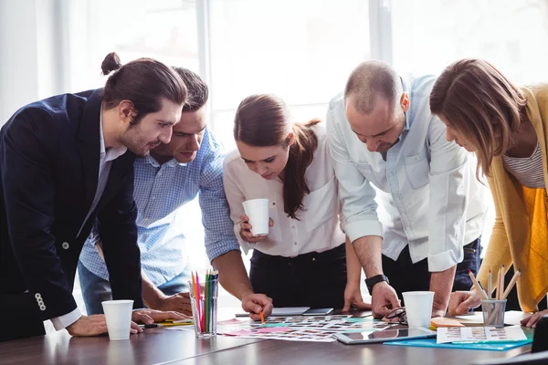 Editors looking at photos on table — Stock Photo, Image