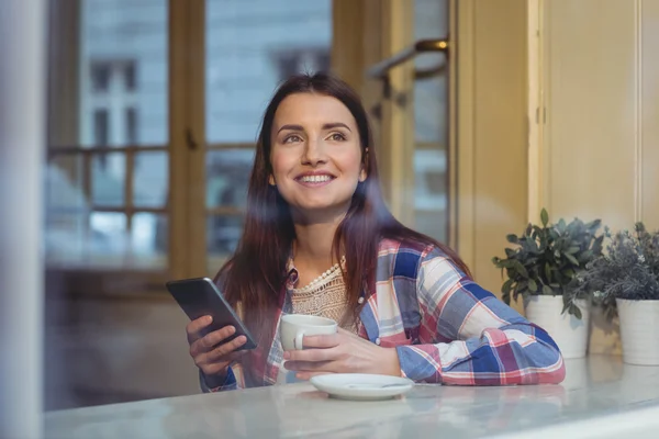 Женщина с мобильным телефоном в кафе — стоковое фото