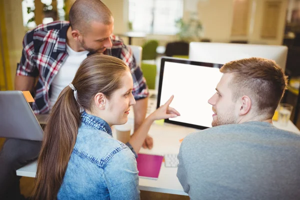 Businesswoman pointing on computer while discussing — Stock Photo, Image