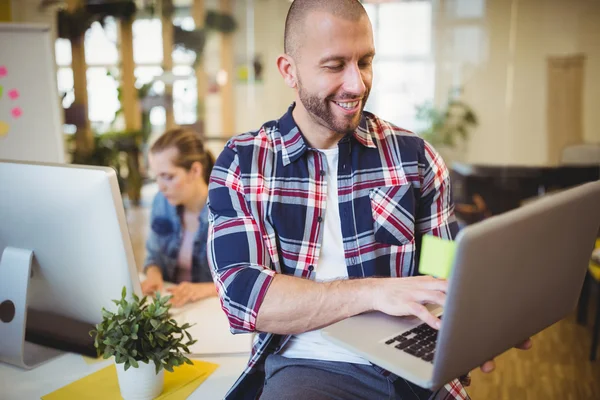 Businesman using laptop at creative office — Stock Photo, Image