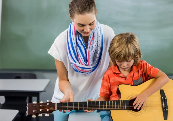 Enseignant aidant boyto jouer de la guitare — Photo