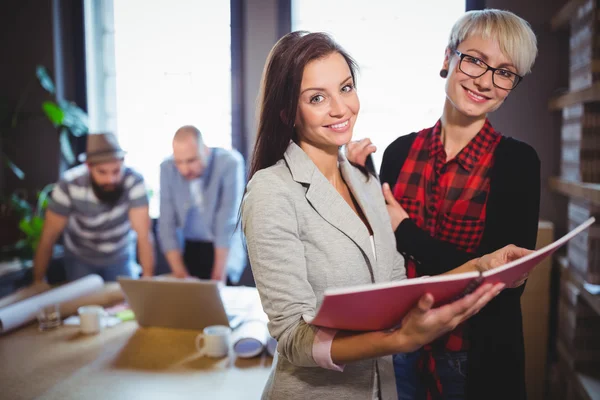 Compañeros de trabajo de pie con archivo en la oficina creativa — Foto de Stock