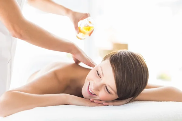 Masseur pouring massage oil on woman — Stock Photo, Image