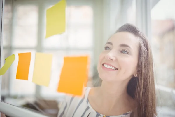 Femme d'affaires regardant des notes adhésives — Photo