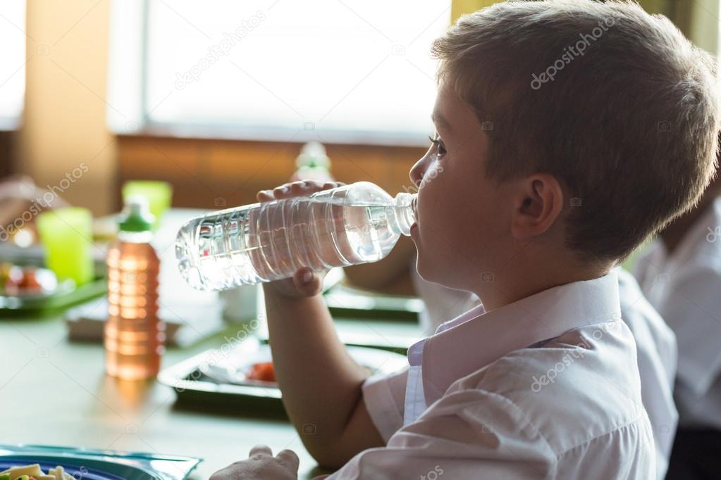Schoolboy drinking water Stock Photo by ©Wavebreakmedia 114919508