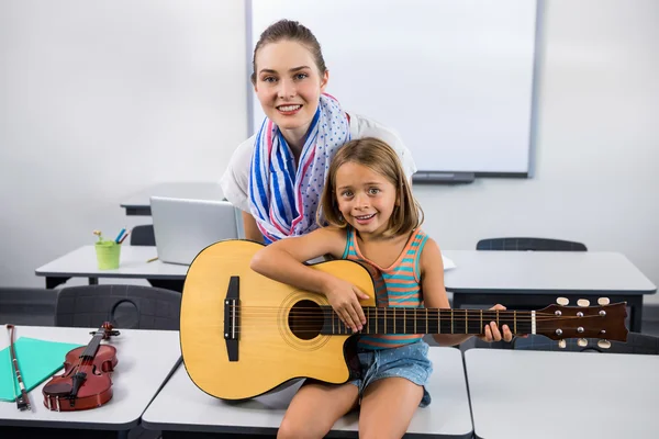 Profesor ayudando a chica a tocar la guitarra —  Fotos de Stock