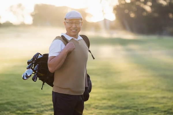Uomo che trasporta borsa da golf — Foto Stock
