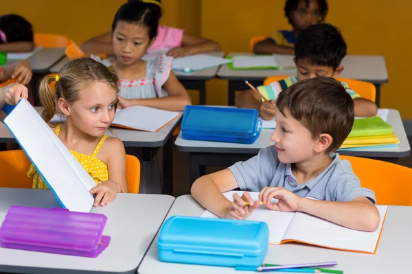 Menina mostrando livro para colega de classe — Fotografia de Stock