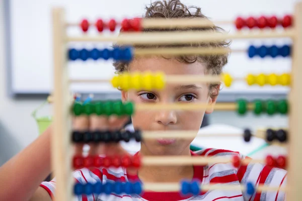 Jongen spelen met abacus in klas — Stockfoto