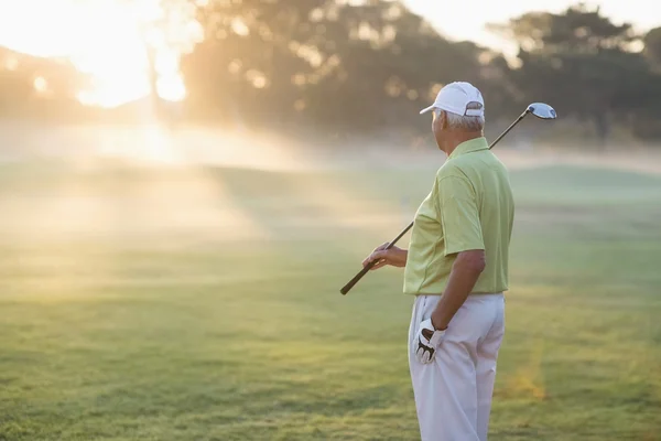 Reifer Golfer steht auf Feld — Stockfoto