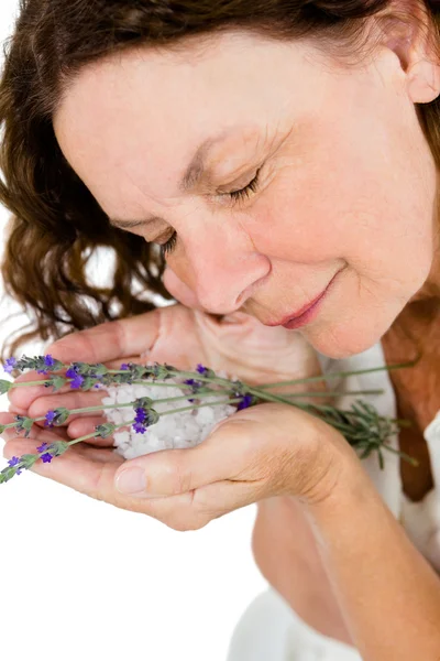 Mulher madura cheirando flores — Fotografia de Stock