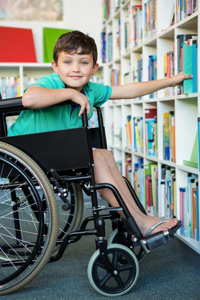 Elementära handikappade pojken söka böcker — Stockfoto