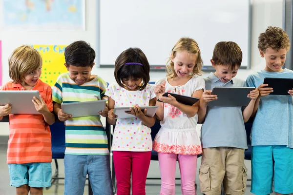 Lachende schoolkinderen met behulp van digitale tablet — Stockfoto