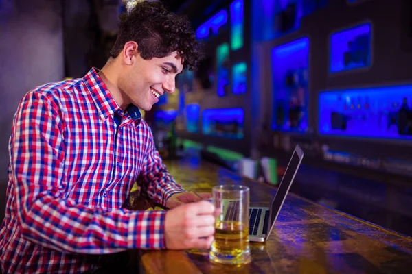 Homem usando laptop no balcão de bar — Fotografia de Stock