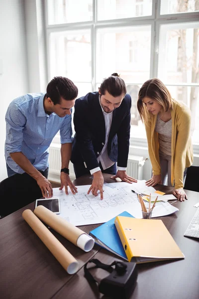 Diseñador de interiores con compañeros de trabajo mirando el plano — Foto de Stock