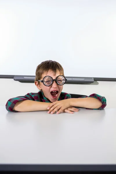 Niño bostezando mientras está sentado en la mesa —  Fotos de Stock