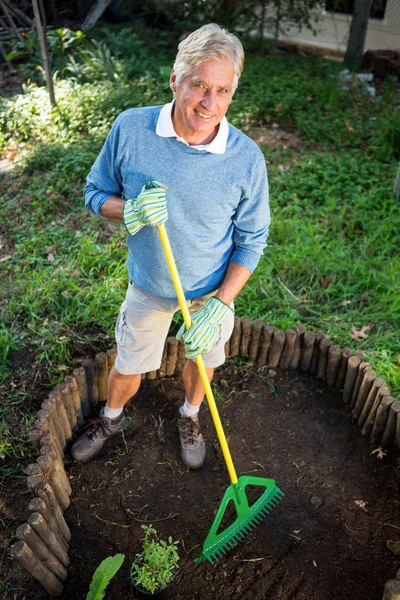 Gärtner benutzt Rechen im Garten — Stockfoto