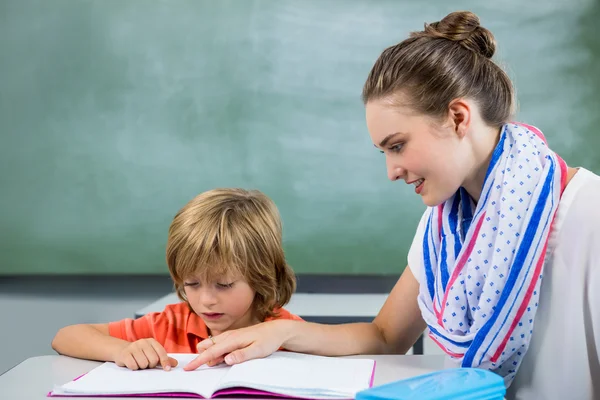 Profesor ayudando a niño a leer libro — Foto de Stock